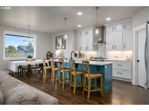 a open dining room with kitchen island furniture a chandelier stainless steel appliances and a kitchen view
