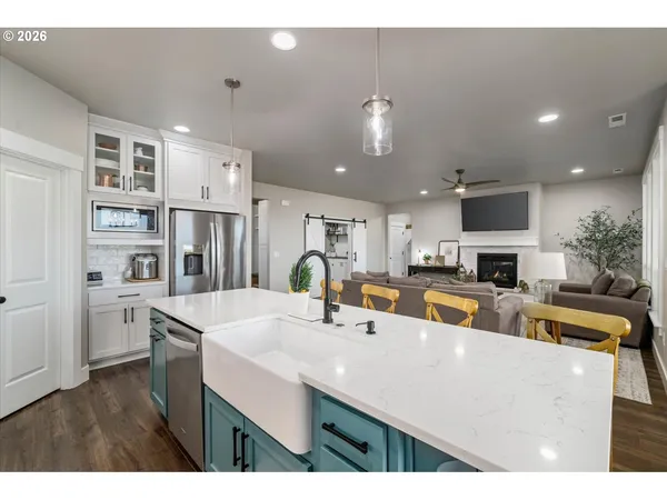 a kitchen with stainless steel appliances a sink a stove top oven a counter space and cabinets