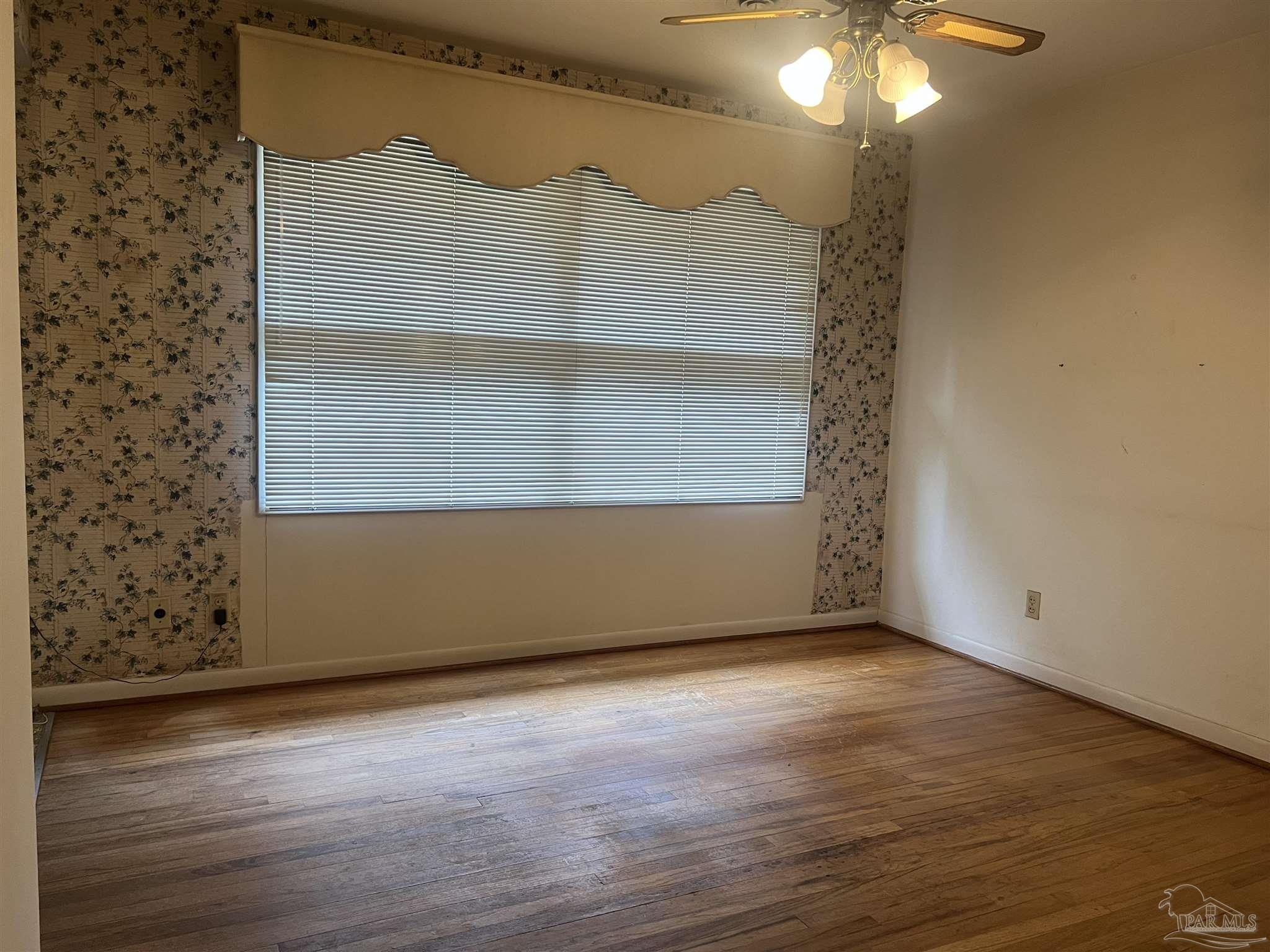 6020 Hilltop Road Pensacola, FL 32504 - Photo 4 of 27 an empty room with wooden floor and fan
