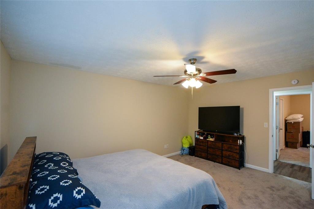 2895 Fairview Road Covington, GA 30016 - Photo 14 of 31 a bedroom with a bed and a flat tv screen on dresser