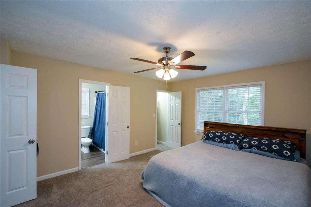 2895 Fairview Road Covington, GA 30016 - Photo 15 of 31 a spacious bedroom with a bed and a chandelier