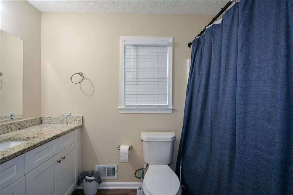 2895 Fairview Road Covington, GA 30016 - Photo 16 of 31 a bathroom with a granite countertop toilet a sink and a mirror