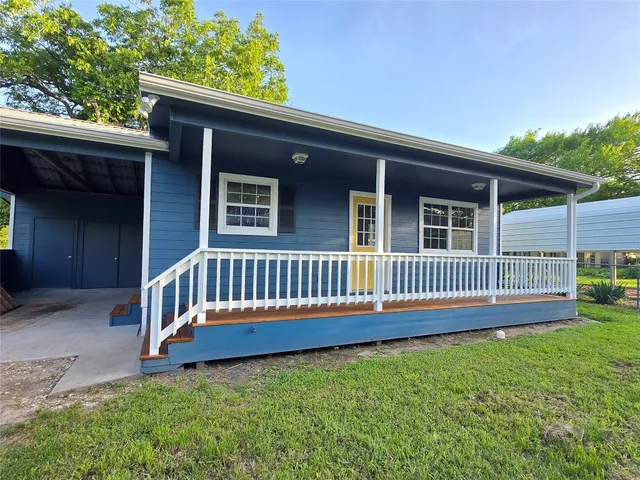 a view of a house with a yard and deck