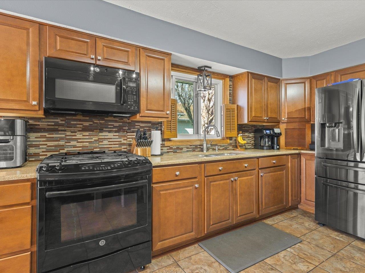 536 Carpenter Street Belvidere, IL 61008 - Photo 13 of 39 a kitchen with granite countertop a stove top oven microwave and refrigerator