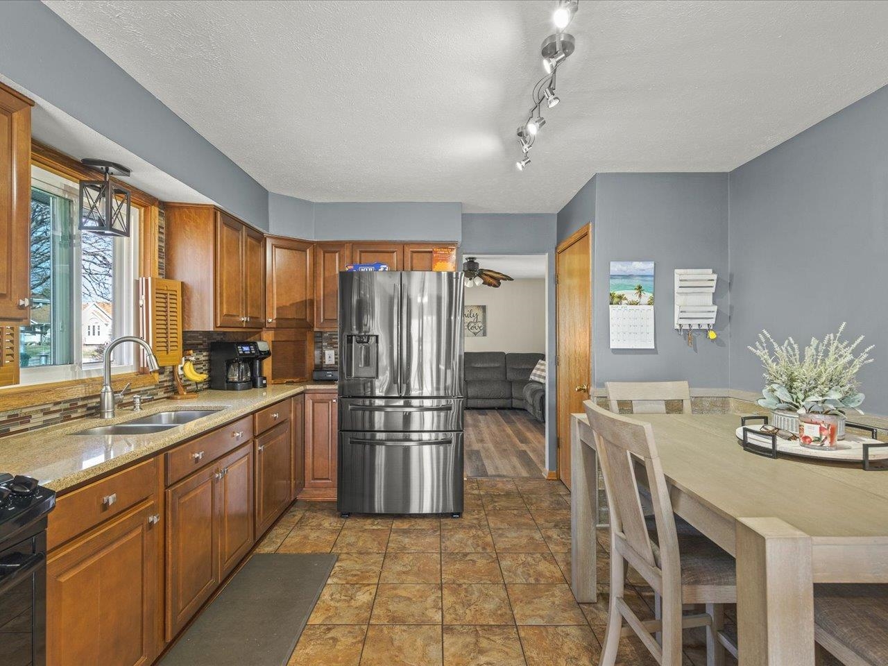 536 Carpenter Street Belvidere, IL 61008 - Photo 17 of 39 a kitchen with stainless steel appliances granite countertop a refrigerator a sink dishwasher a dining table and chairs with wooden floor