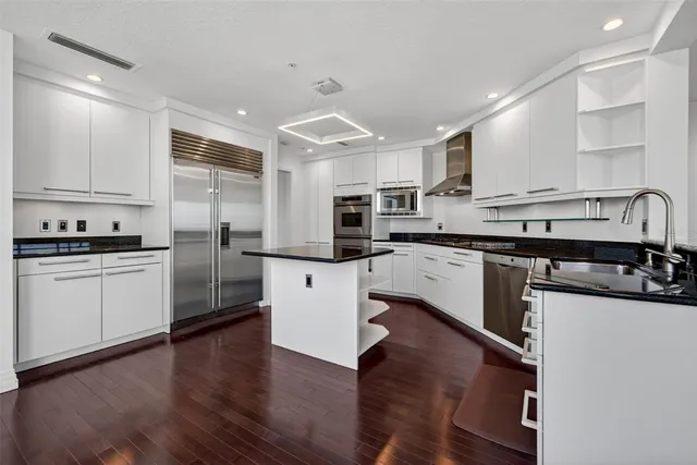 a kitchen with stainless steel appliances granite countertop a sink a stove and a refrigerator
