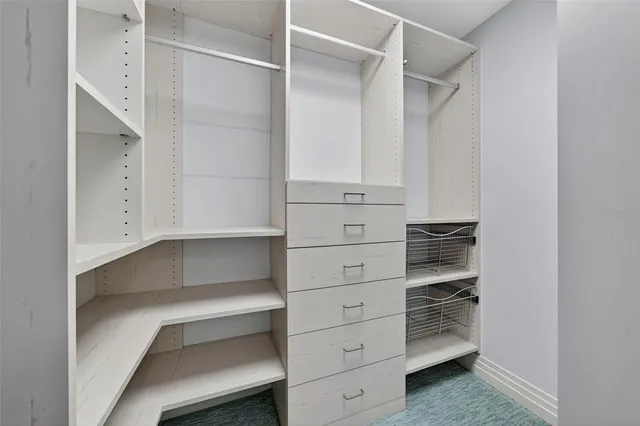 a view of walk in closet with empty racks