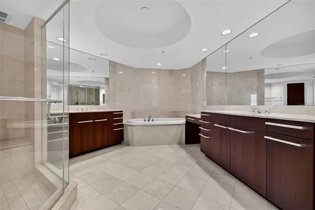 a bathroom with a tub a sink shower and mirror