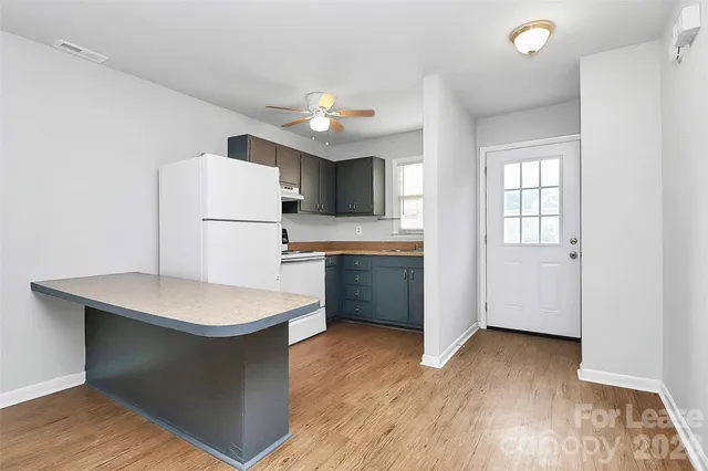 a kitchen with sink a refrigerator and microwave