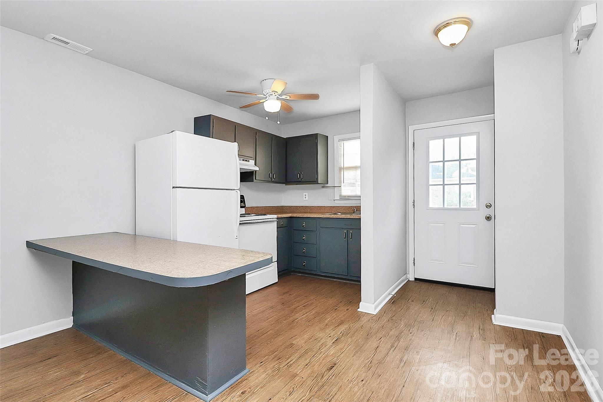 a kitchen with sink a refrigerator and microwave