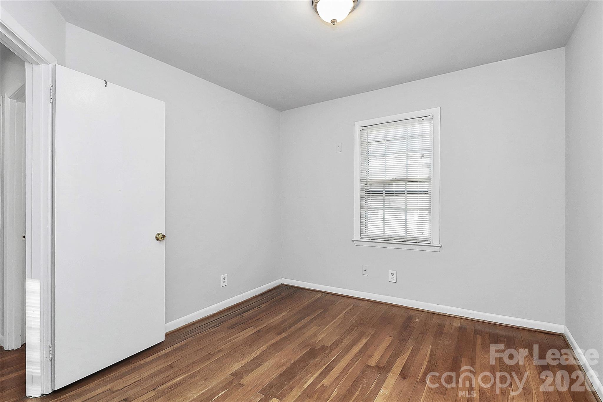 4220 Castleton Road Charlotte, NC 28211 - Photo 11 of 17 an empty room with wooden floor and windows