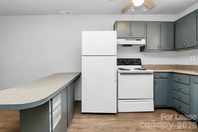 a kitchen with stainless steel appliances cabinets and wooden floor