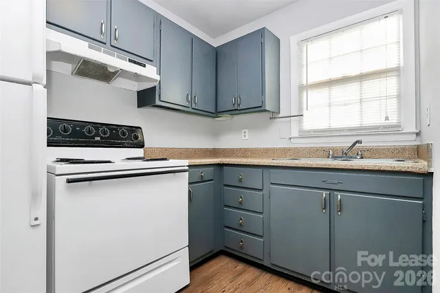a kitchen with cabinets appliances a sink and a window