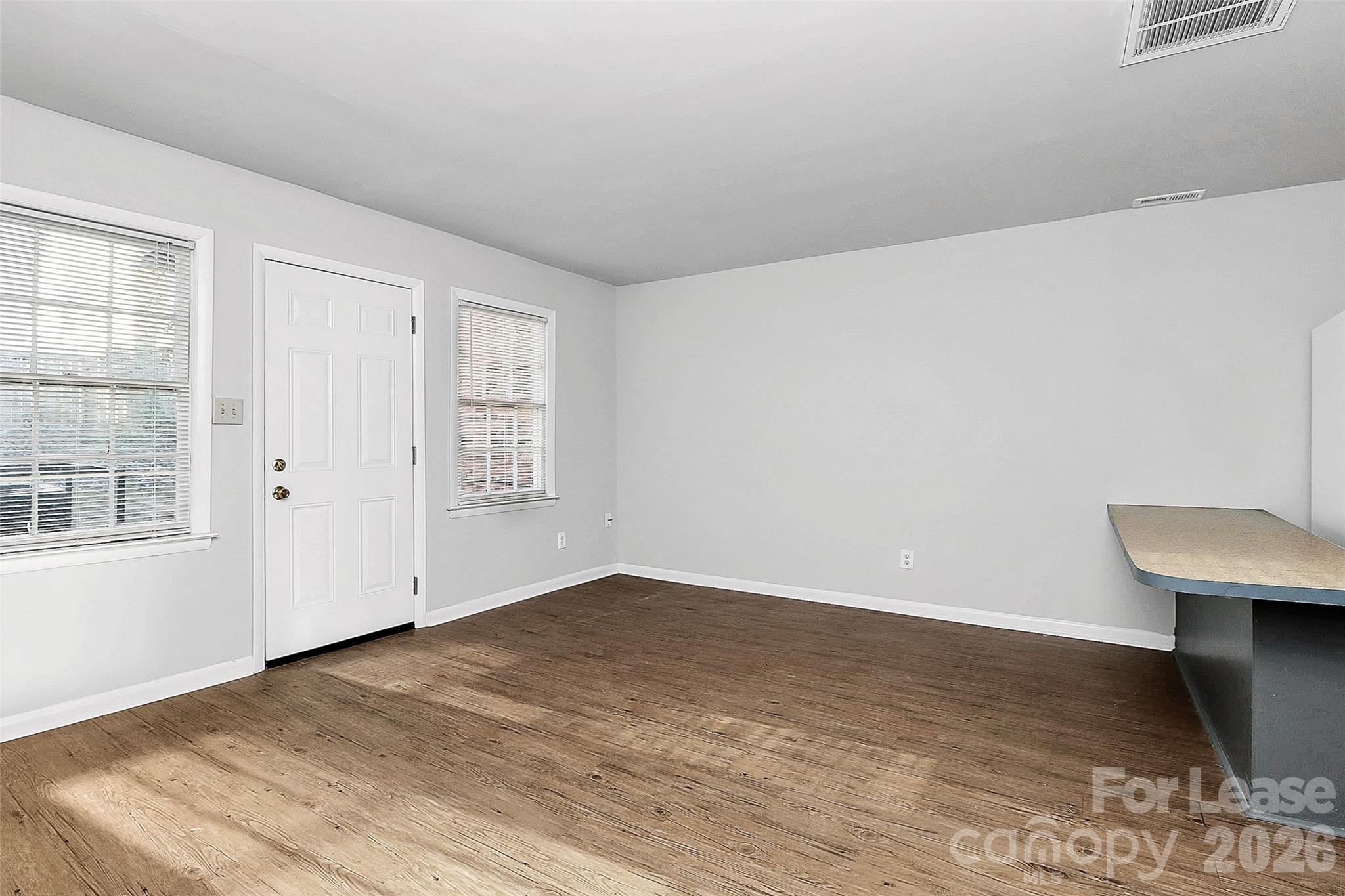 4220 Castleton Road Charlotte, NC 28211 - Photo 4 of 17 an empty room with wooden floor and windows