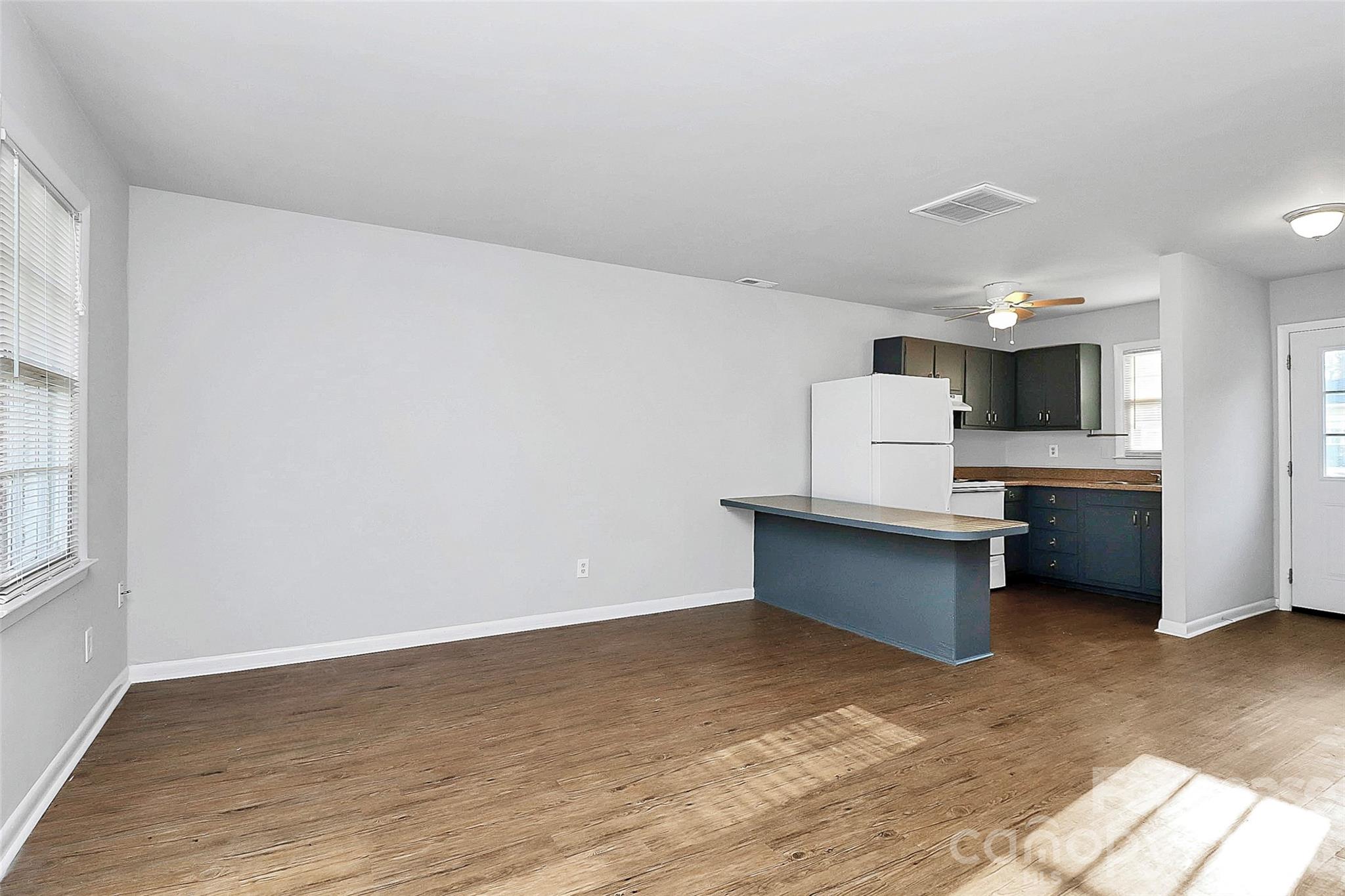 4220 Castleton Road Charlotte, NC 28211 - Photo 5 of 17 a large white kitchen with a stove a sink dishwasher and a refrigerator with wooden floor