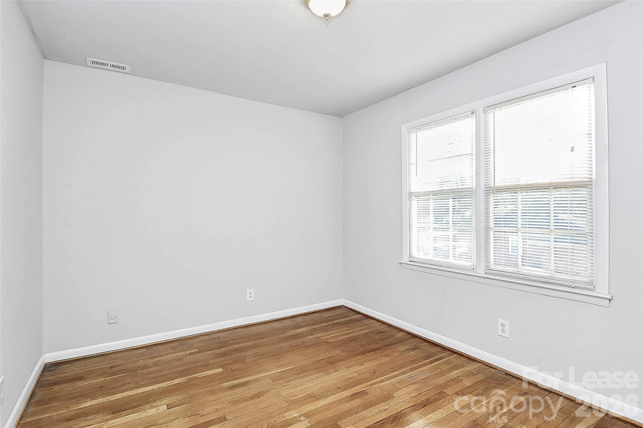 4220 Castleton Road Charlotte, NC 28211 - Photo 8 of 17 an empty room with wooden floor and windows