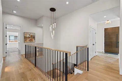 a view of a hallway with wooden floor and staircase