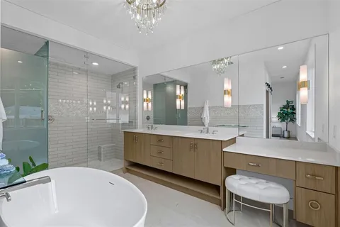 a bathroom with a granite countertop sink a toilet a mirror and shower