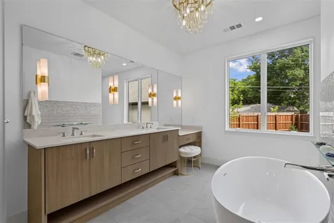 a bathroom with a double vanity sink a mirror and a bathtub