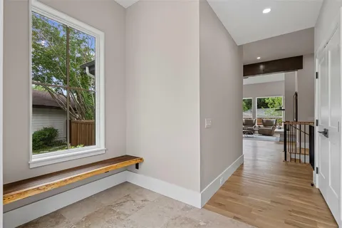 a view of a hallway with wooden floor and windows