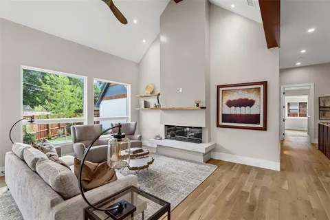 a living room with furniture a large window and a fireplace
