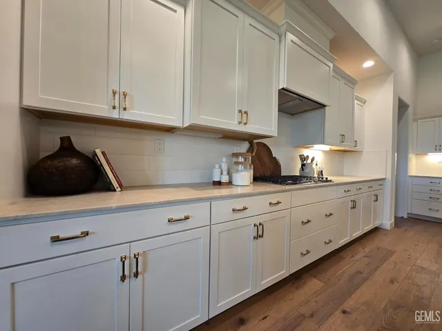 a kitchen with granite countertop white cabinets and white appliances