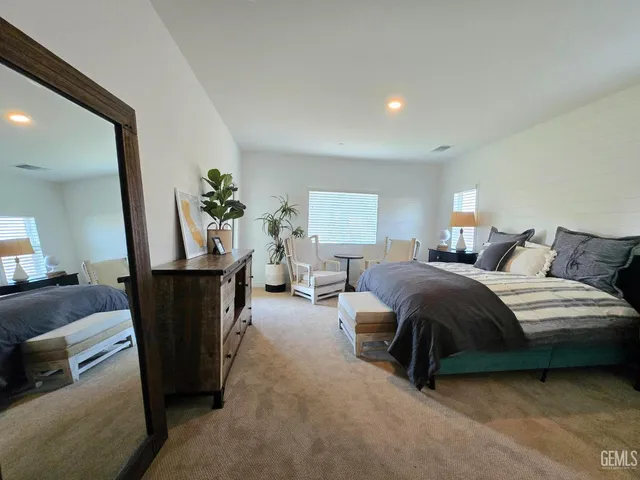 a bedroom with a bed a couch and dresser