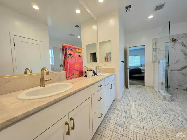 a spacious bathroom with a double vanity sink mirror and shower