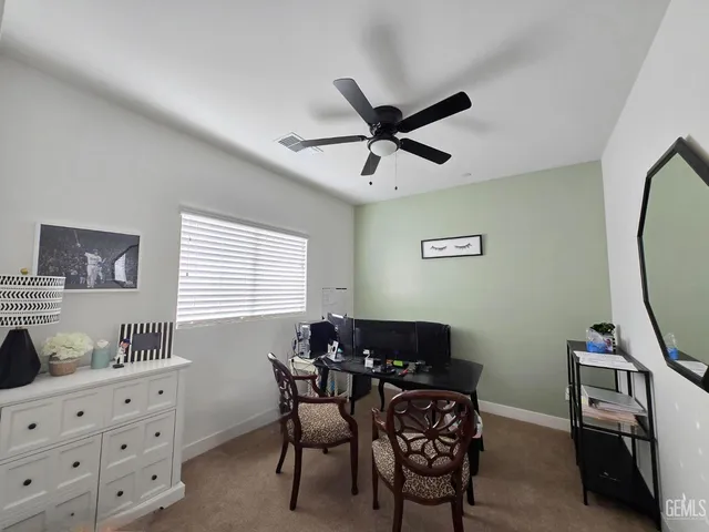 a view of a workspace with furniture and a window