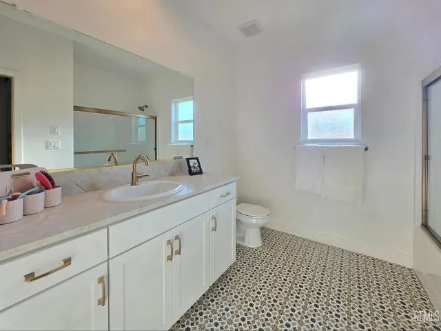 a bathroom with a double vanity sink mirror and toilet