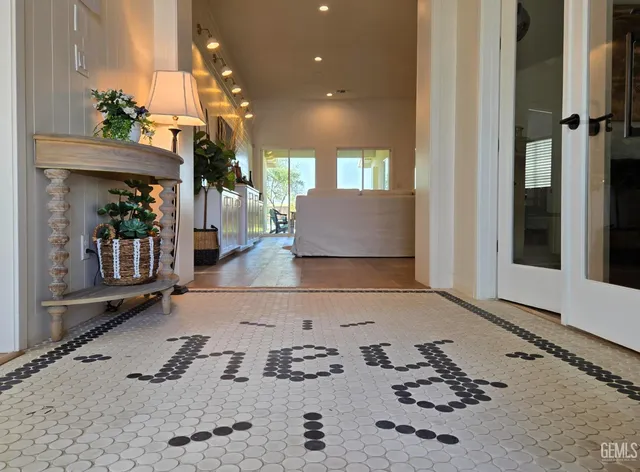 a view of a hallway with a couch and chandelier