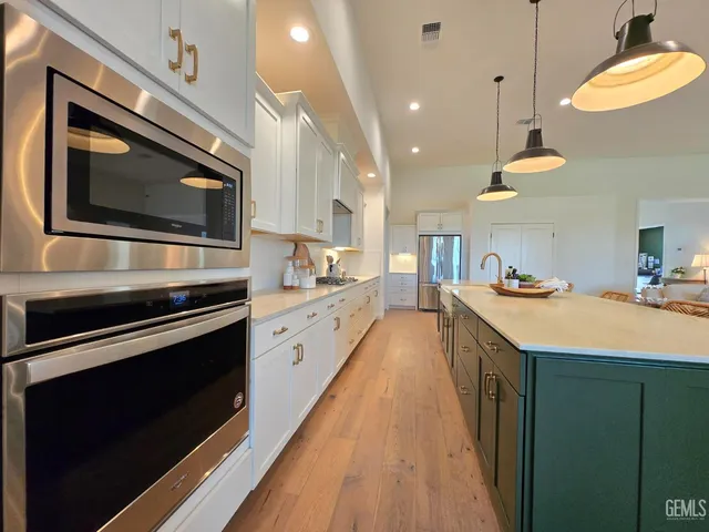 a kitchen with stainless steel appliances kitchen island granite countertop a stove a sink and a microwave