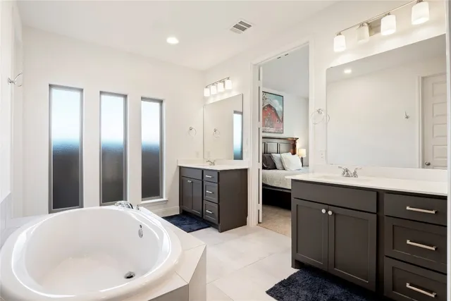 a large bathroom with a tub double sink mirror and