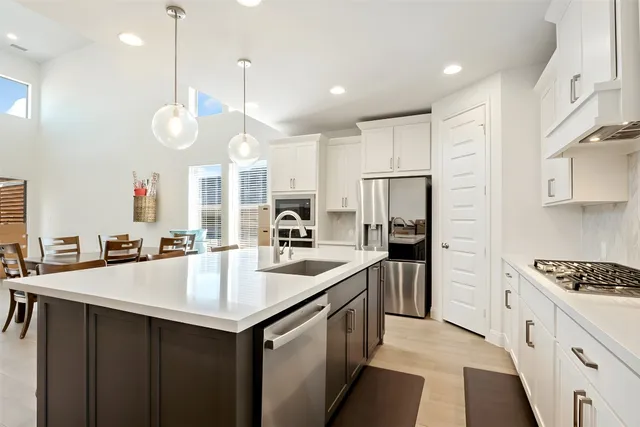 a kitchen with stainless steel appliances granite countertop a sink a stove and a refrigerator
