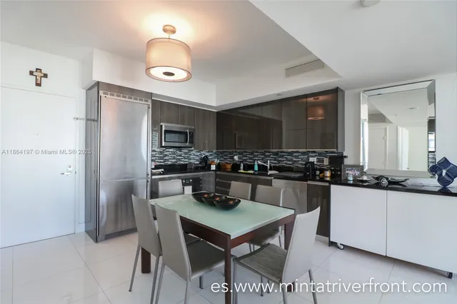 a kitchen with a refrigerator a stove a sink and chairs