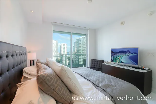 a bedroom with a bed and a large window