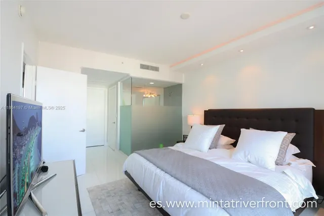 a bedroom with a bed and a refrigerator