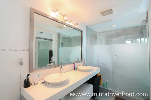 a bathroom with a sink a mirror and a shower