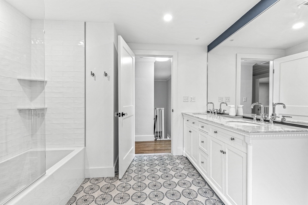 15 Rustic Road Stoneham, MA 02180 - Photo 28 of 42 a bathroom with a granite countertop sink a mirror a bathtub and shower