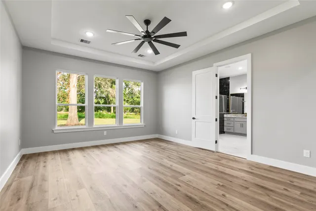an empty room with a window and wooden floor