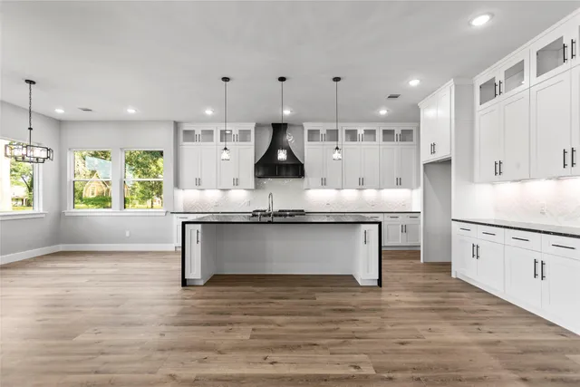 a kitchen with stainless steel appliances granite countertop a stove a sink and a refrigerator