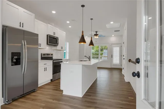 a kitchen with stainless steel appliances kitchen island refrigerator stove and microwave