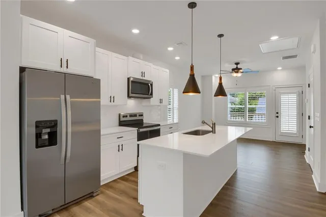 a kitchen with white cabinets and stainless steel appliances