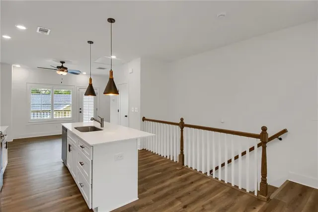 a open kitchen with a sink a window and wooden floor