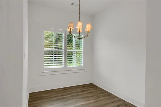 a view of a room with wooden floor and windows