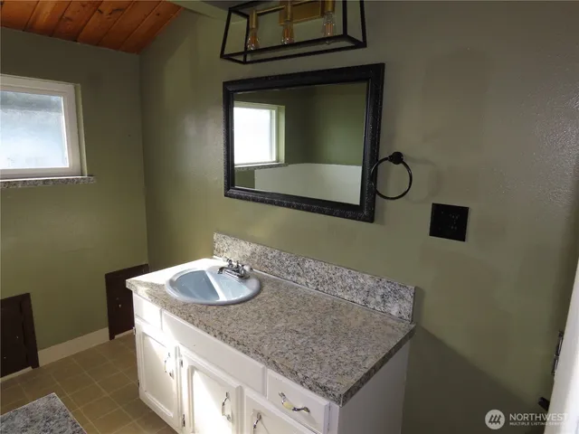 a bathroom with a granite countertop bathtub and window