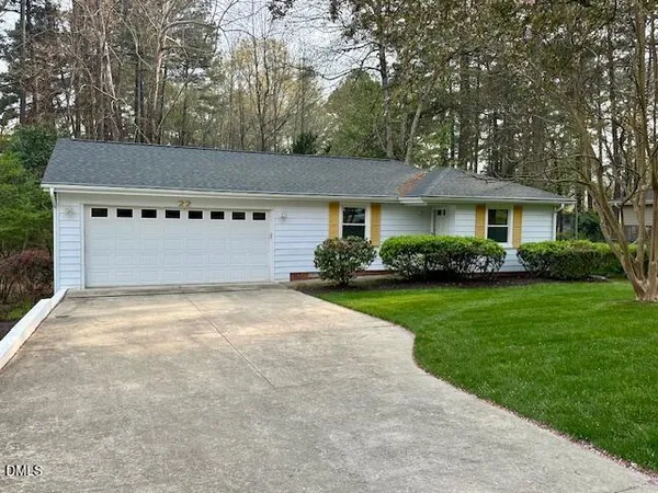 a front view of a house with a garden and plants