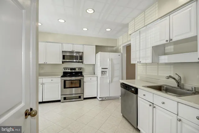 a kitchen with cabinets and stainless steel appliances