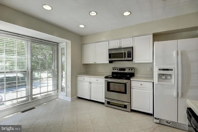 a kitchen with stainless steel appliances granite countertop a stove a refrigerator and a microwave