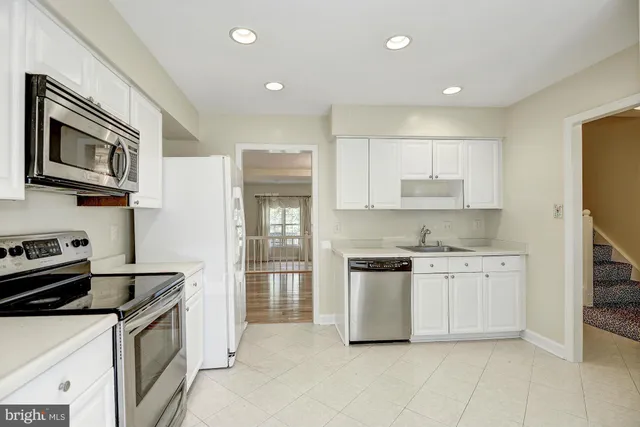 a kitchen with stainless steel appliances granite countertop a stove top oven a sink dishwasher and a refrigerator